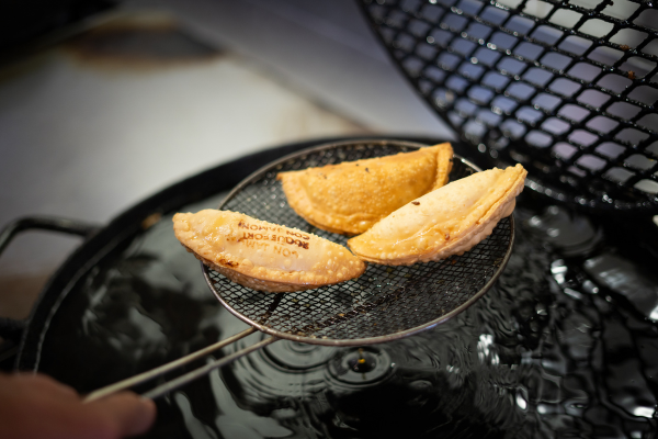 3 empanadas fritas al disco siendo escurridas